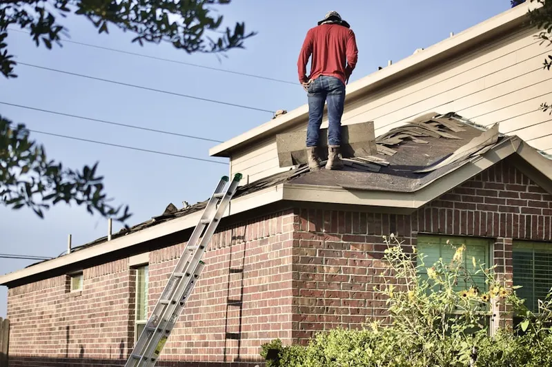 Professional roofer working on a residential roof in Moody